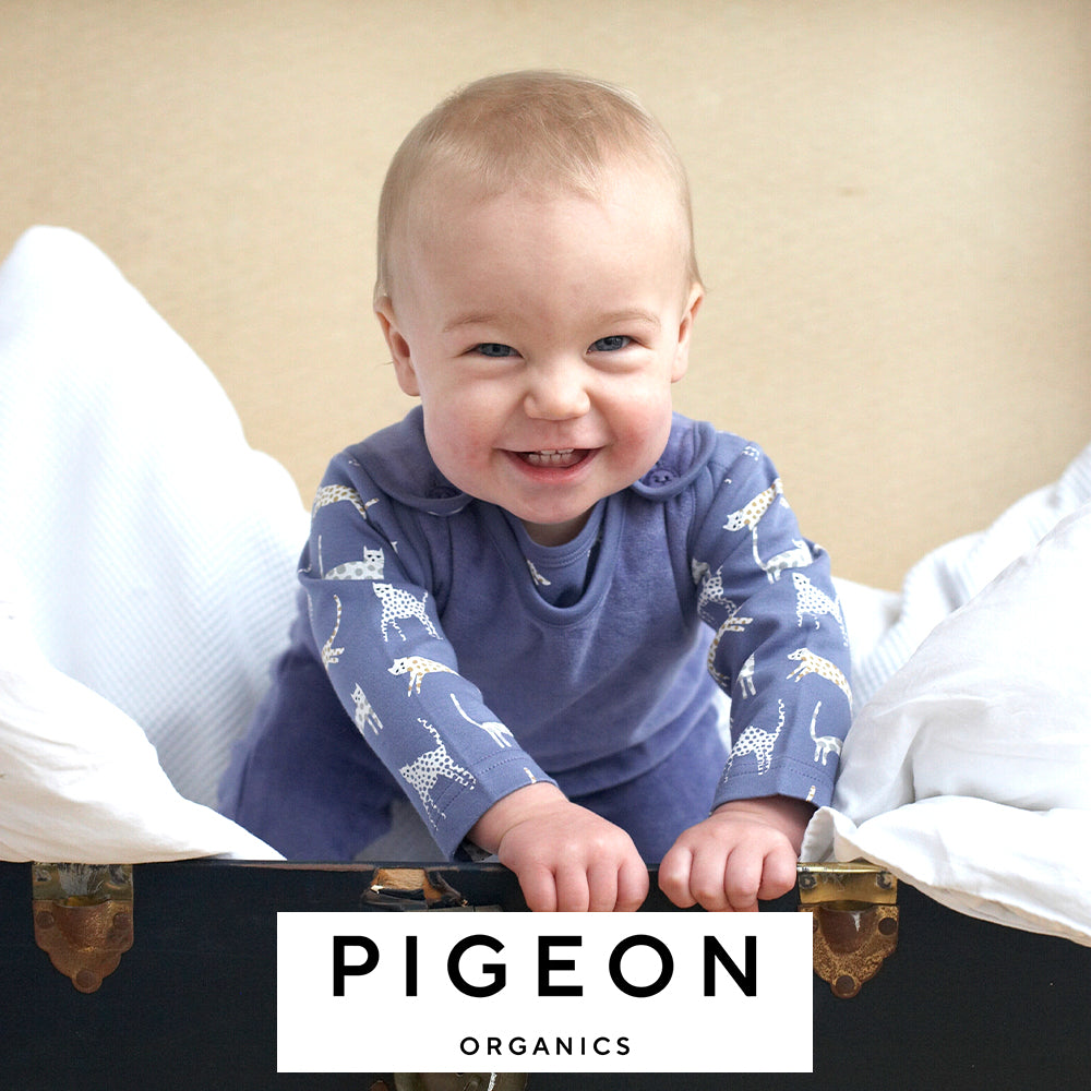 Image of a baby wearing a blue Pigeon Organics outfit, alongside the Pigeon Organics logo
